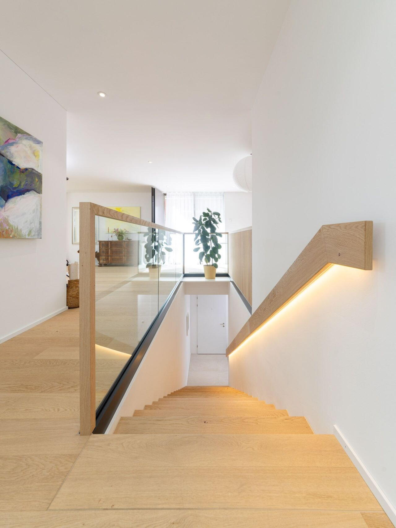 Individueller Innenausbau: indirekt beleuchteter Treppengriff, Eichenholzparkett