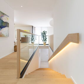 Aménagement intérieur personnalisé : poignée d'escalier à éclairage indirect, parquet en chêne